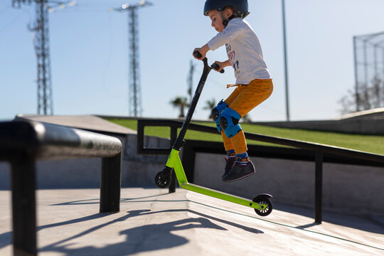 Performing Scooter Jump at Skatepark