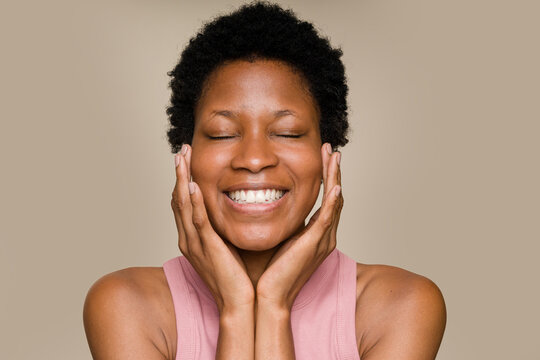 woman touching her face and smiling