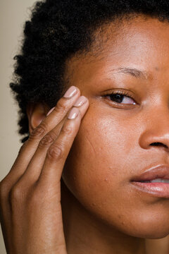 woman touching her face examining skin texture