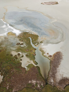 Water and  earth making abstract art. Aerial image