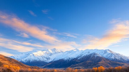 Scenic mountain landscape with snow-capped peaks and blue sky.