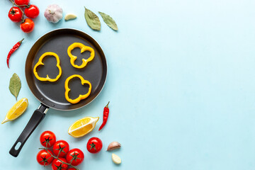 Cooking desk with frying pan and cutting vegetables, top view