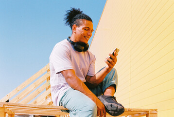 Smiling Man Browsing Phone in Sunlight