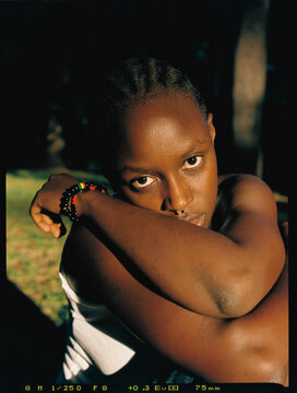 Analog portrait of black lady leaning on her arms with a tense look