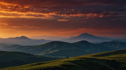 Fototapeta premium Dramatic sunset over rolling hills and mountains.