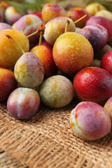 Pile of tasty ripe plums on table, closeup