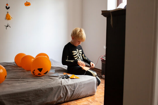 boy make Halloween skeleton flags garland 