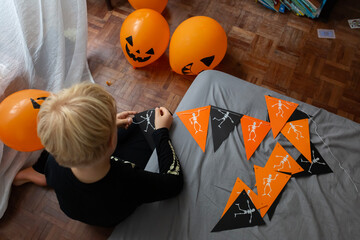boy make Halloween skeleton flags garland 