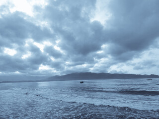 Calm weather on sea or ocean with clouds
sea with sun and cloudy sky background, calm ocean water surface, relaxing sunset or sunrise morning atmosphere, dark natural texture reflection.