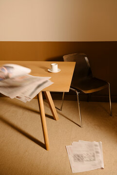 Minimalist Office Setup with Chair and Flying Papers