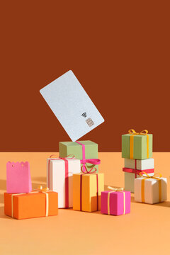 A stack of colorful gift boxes with a credit card floating on a box