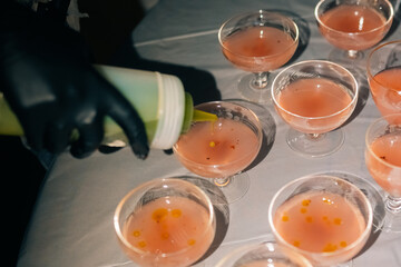 Bartender preparing cocktails with dropper at a party