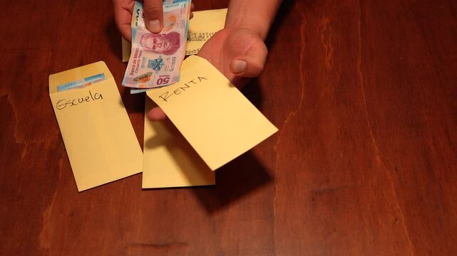 contando y separando el dinero recibido en sobres amarillos planificacion y organizacion de las finanzas para llevar una economia sana y productiva