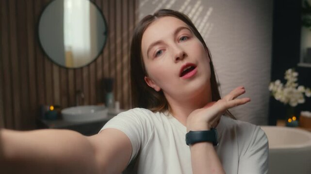 Smiling carefree girl beauty blogger woman influencer happy funny photo mobile phone camera selfie social media beauty blog vlog skincare cosmetics makeup in home bathroom grimace female pretty face