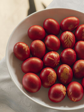 Decoratively dyed red eggs arranged in a bowl for greek easter