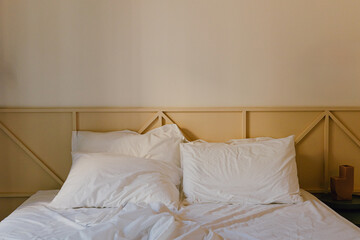 Soft white pillows on a bed in a minimalist bedroom