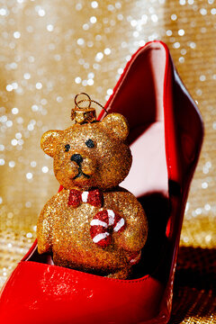 golden teddy bear in a red high-heeled shoe