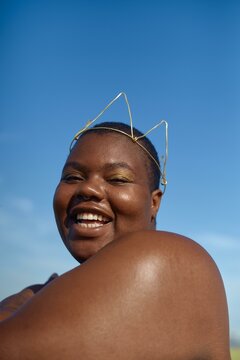 Woman in crown under a blue sky