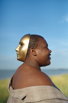 Emblem of duality with a golden mask at sunrise
