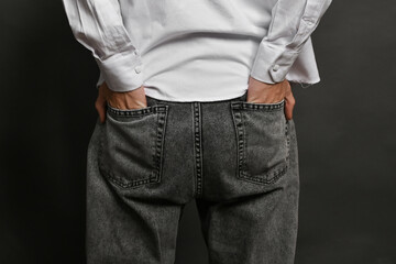 The man's hands are in the back pockets of his trousers, his thumbs are peeking out. the concept of hidden dominance.