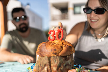 Woman lighting candles on a panettone for 30th birthday