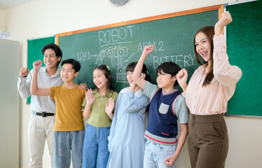 Portrait of a teacher and kids in a classroom where children have pleasure learning