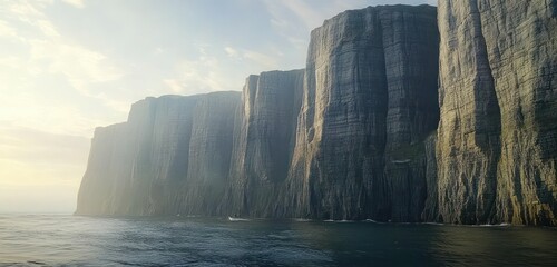 Towering cliffs rising from the ocean, viewed from a low perspective on a boat, capturing the scale and grandeur.