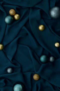 Elegant teal fabric draped with golden and silver ball ornaments