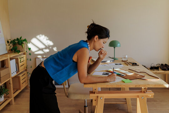 Fashion designer working on sketches in her studio