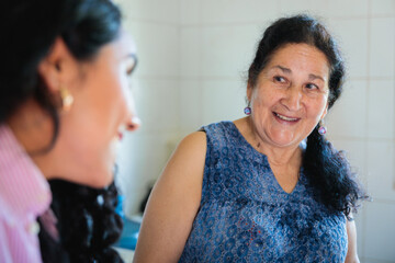 Senior mother and young daughter sharing and talking