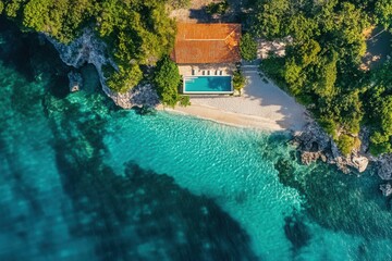 Aerial view of secluded beach house with infinity pool.