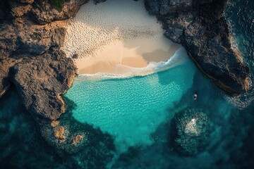 Secluded cove with turquoise water, white sand beach, and dark rocks.