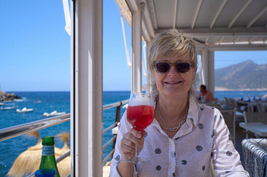 Woman enjoying a refreshing Campari and Soda at a seaside restaurant