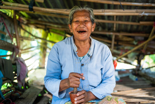 Smiling Elderly Thai Woman Chewing Betel Nut in Rural Thailand