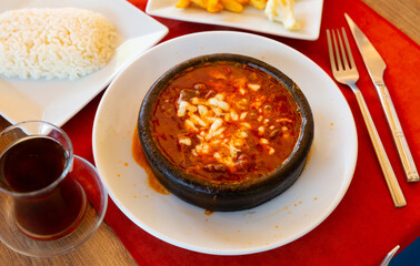 Fresh Osmanli kebab served on table with rice, fried potato and tea.
