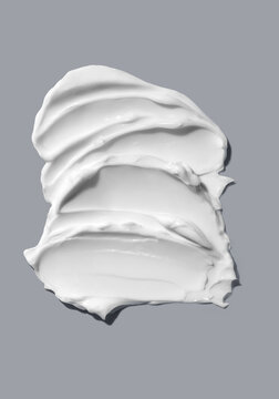 Swatch of moisturizing face, body cream on plain gray background. 