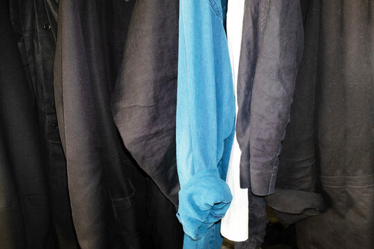 Clothes with various textile fabric materials hanging on a cloth rack