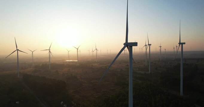Beautiful windmill against sunrise sky, wind turbine farm, renewable energy, less carbon footprint, clean green energy