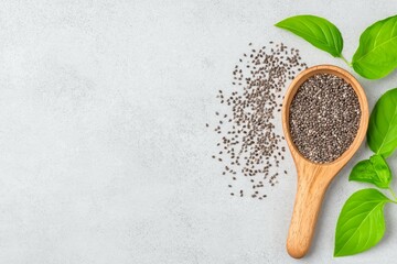Wooden Spoon with Chia Seeds and Fresh Green Leaves on Light Background