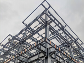 Steel frame structure, steel frame workshop is under construction against a blue sky, blue steel in steel installation construction