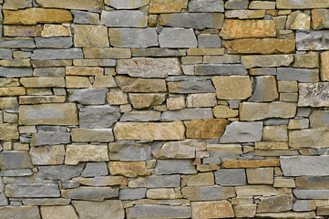 A brick wall made of stones of different shapes. background