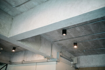 Exposed concrete ceiling with modern lighting fixtures