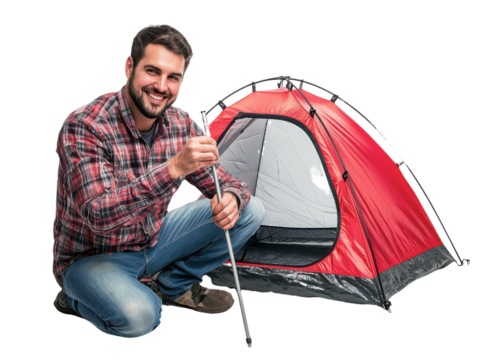 Man is sitting on the ground with a tent in front of him. He is smiling and holding a stick. Concept of adventure and excitement, as the man is preparing for a camping trip