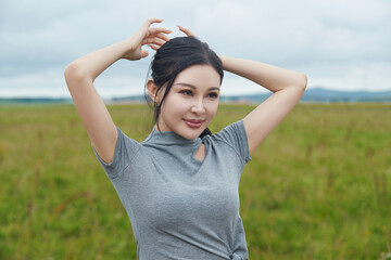 Beautiful women taking photos in the grassland flower sea in midsummer