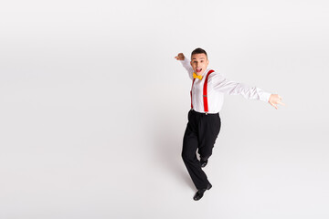 Young man in vintage style dancing energetically against a white background