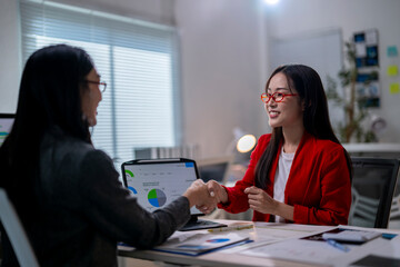 Two women shaking hands in a business meeting
