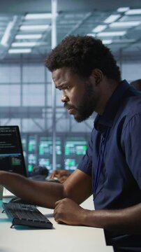 Vertical video Engineer in data center implementing advanced AI driven predictive maintenance systems to proactively identify and resolve potential hardware failures before they impact operations
