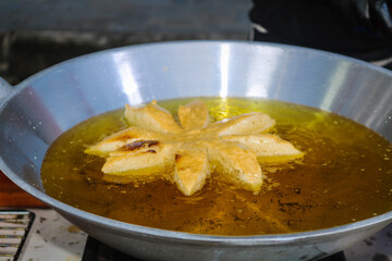 Bakso mekar is fried in a frying pan full of oil. Fried meatballs are street snacks served with sauce and mayonnaise.