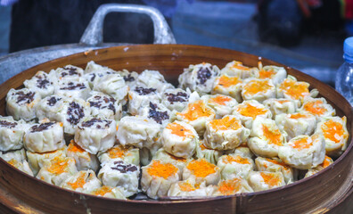 Dimsum with various flavors in bamboo steamer siomay. Dim sum with mentai sauce, cheese dim sum, seafood dim sum being steamed