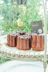 Homemade Canelés de Bordeaux,Caneles is a small pastry with rum and vanilla on a wooden plate,traditional French sweet dessert,Selective focus.